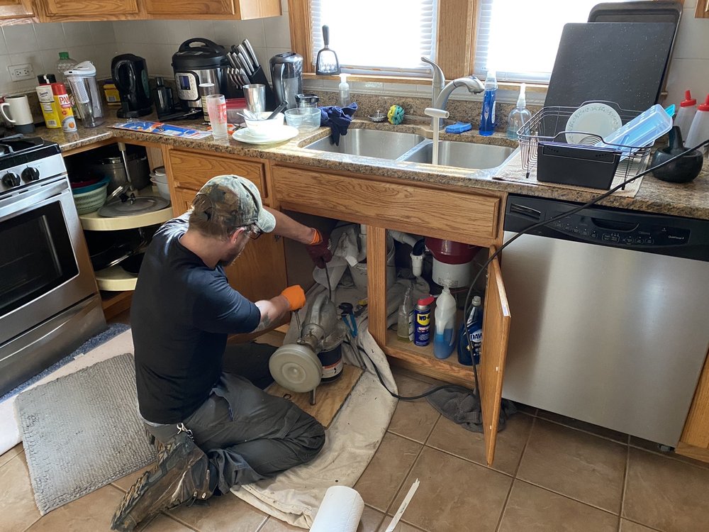 Plumber rodding a kitchen sink