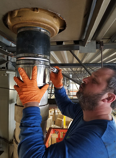 Kevin the plumber replacing a roof head drain in a commercial building.