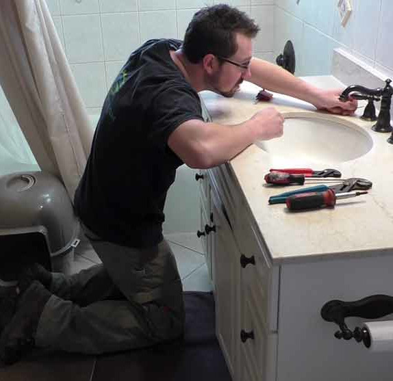plumber working on a bathroom faucet 