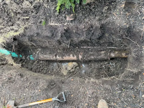 Excavated sewer pipe before spot repair